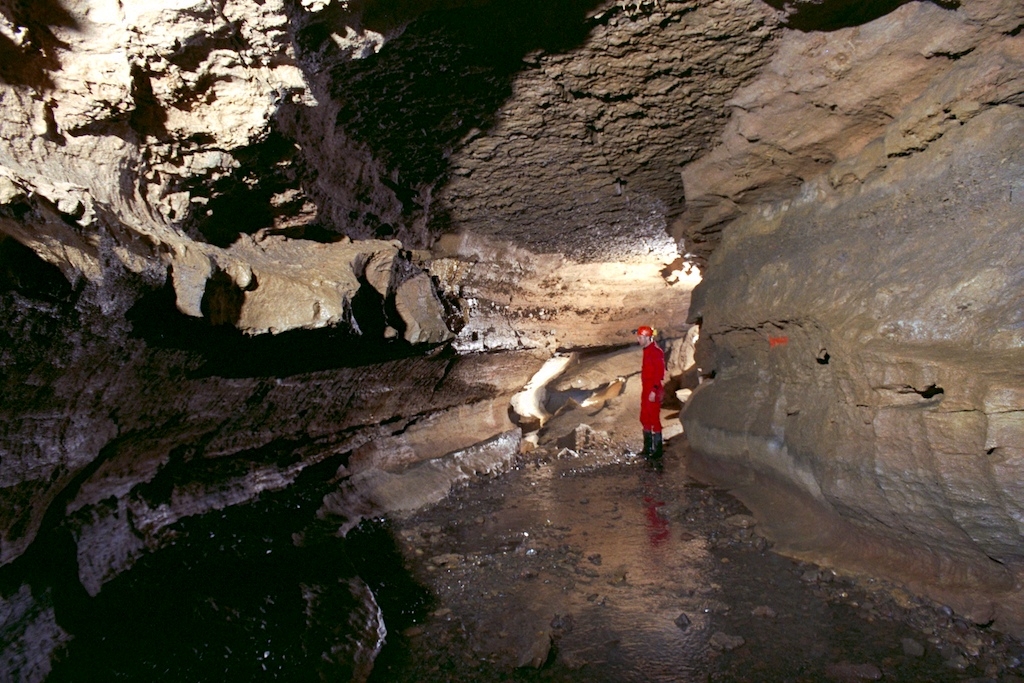 Clarksville Cave, New York photograph. This caver is wearing a very typical bright red caver suit. I have one just like it. However, he's sporting better cave boots than what I have.