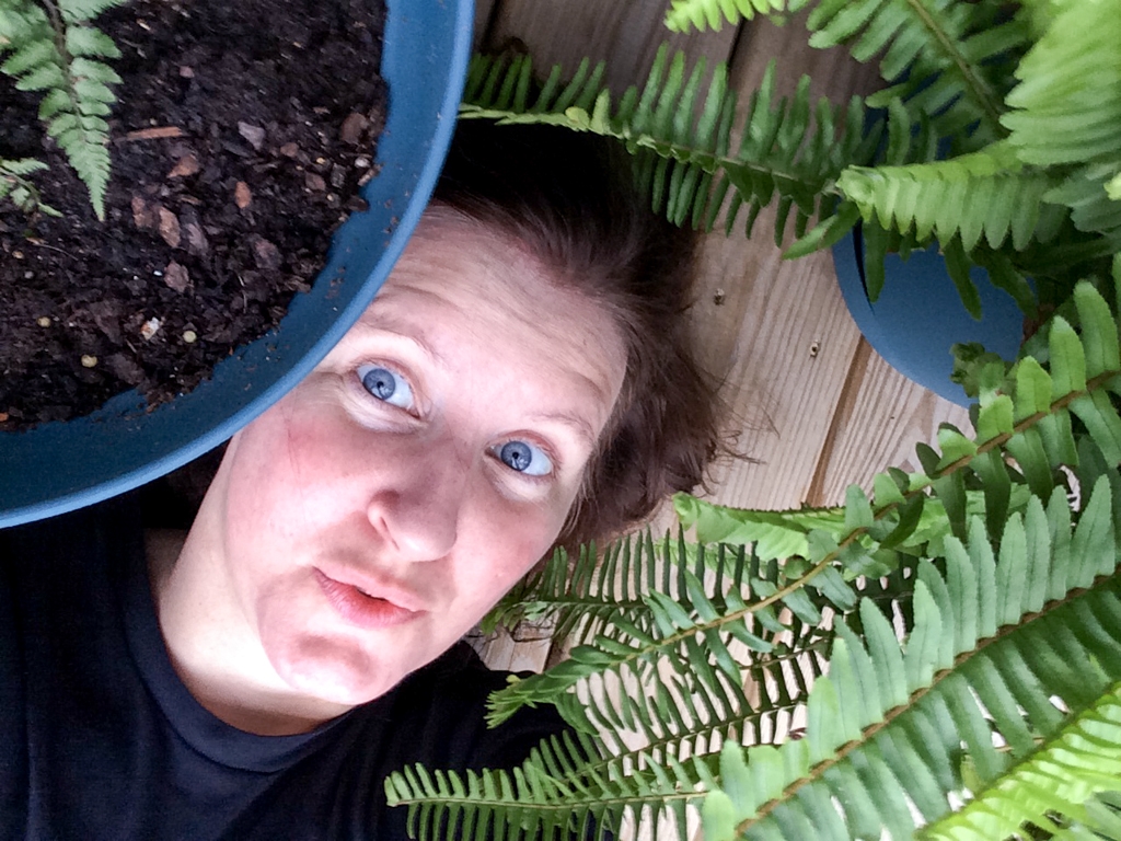 Self portraits photograph. Goofing around amongst the plants. I kept my hair dark brown back then.