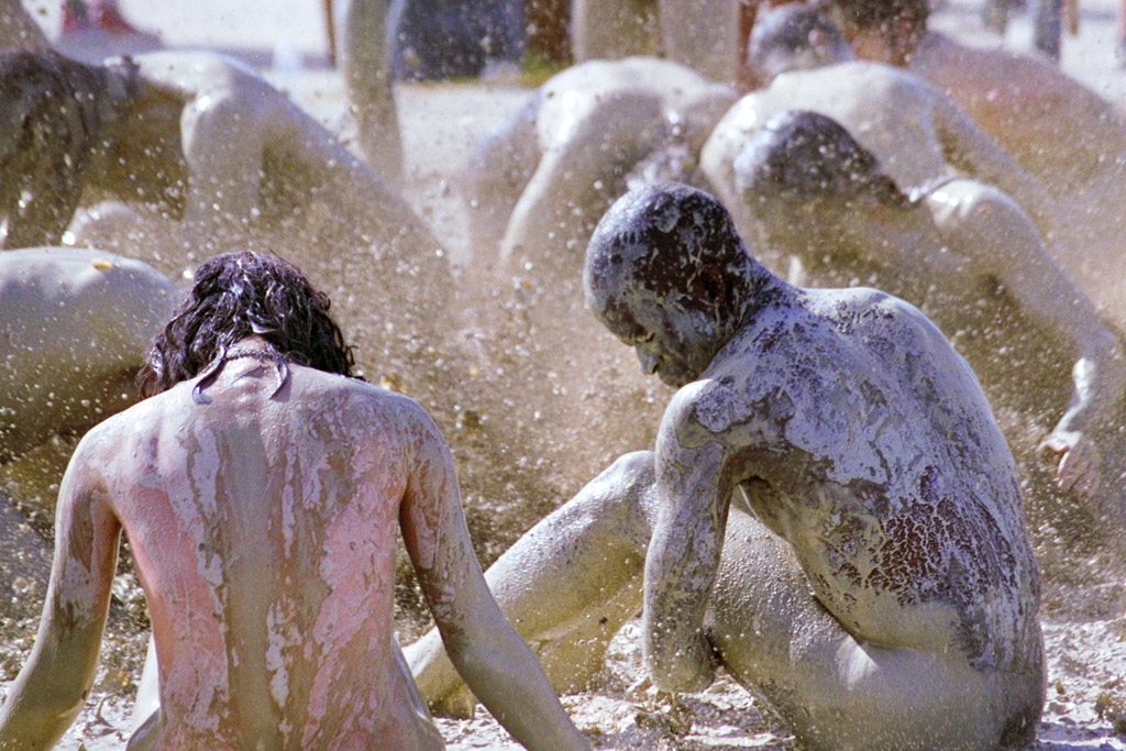Burning Man 1996 photograph. I love this woman's posture. She looks like she's praying. Also, she looks like she was painted red before she got muddy.