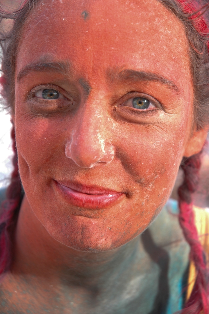 Burning Man 2004 photograph. Lots of people had face or body painting. Her ares are very blue and sparkly! 
