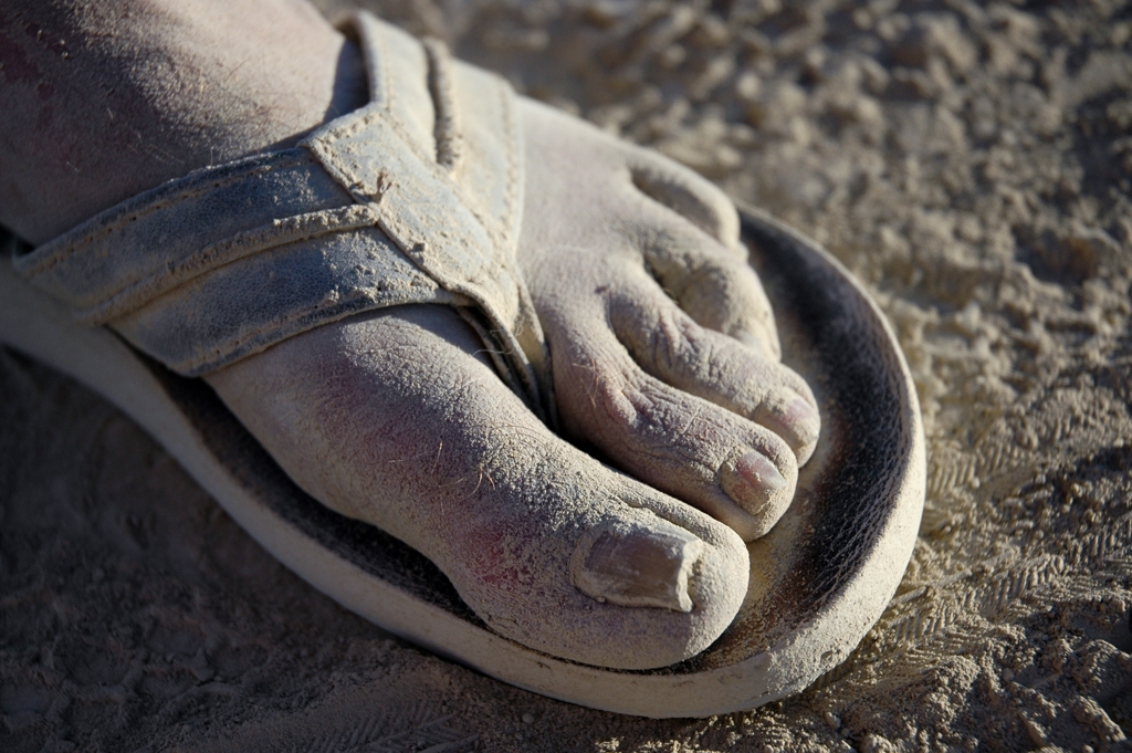 Feet and Shoes photograph. Dusty foot in sandal.