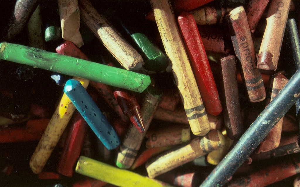 Crayons photograph. Peeled and unpeeled and a little dirty. A peeled green crayon on the left. Apricot on the right.