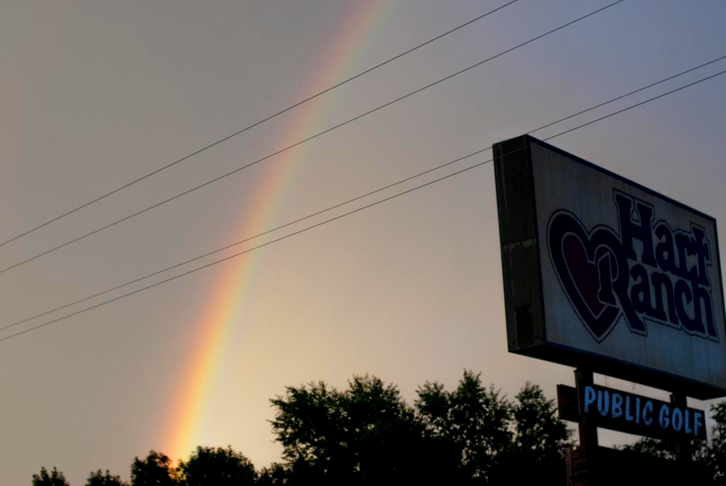Road trip across America photograph. The sign says Hart Ranch, public golf. Everyone pulls over when they see a rainbow. It's a rainbow party!